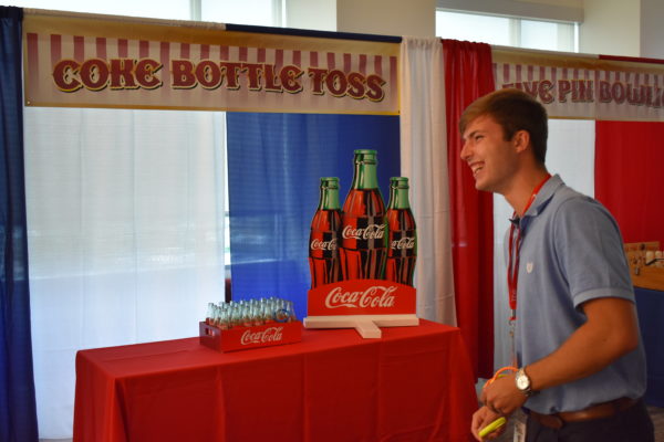 Man playing Coca Cola Coke Ring Toss Carnival Game