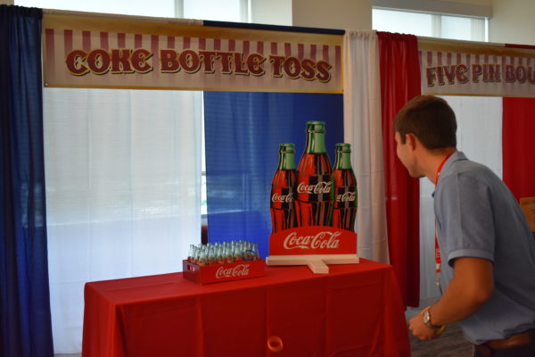 Man playing Coca Cola Coke Ring Toss Carnival Game