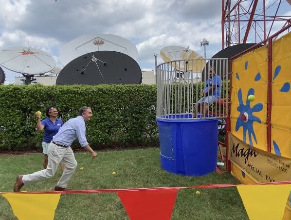 Virginia Governor Northam throwing a ball at a dunking machine