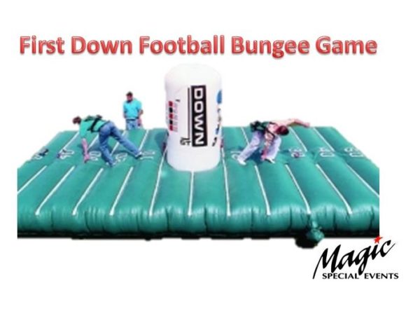Photo showing two contestants pulling against each other in a bungee tug a war on a football theme inflatable