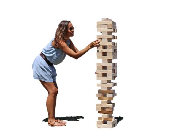 Photo of a woman playing giant Jenga came which consists of 54 wooden blocks