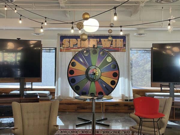 A giant spinning game wheel made of different colors with flashing lights
