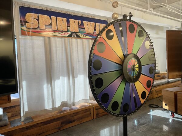 A giant spinning game wheel made of different colors with flashing lights