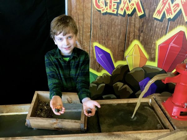 Boy showing gems found in a Portable mining sluice for gem stone mining fun