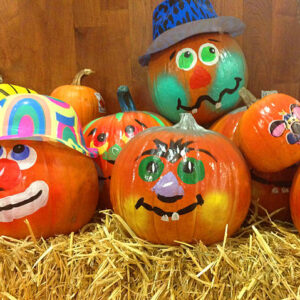 Decorated pumpkins on hay for Halloween.