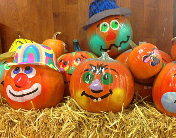 Decorated pumpkins on hay for Halloween.