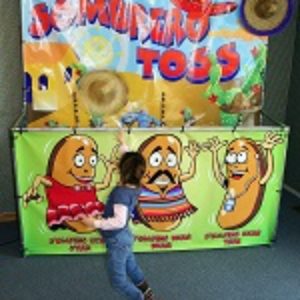 Photo of a carnival game where contestants throw a sombrero hat onto a jumping bean character's head