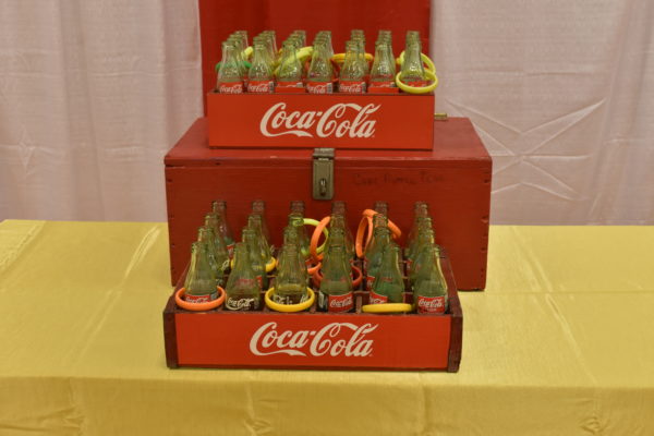 Carnival Game tossing plastic rings over necks of coke bottles