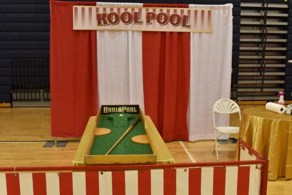 Carnival Game using pool cue to shoot a ball into a hole
