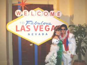 Photo of a prop sign of the famous Welcome to Las Vegas sign with an Elvis Impersonator